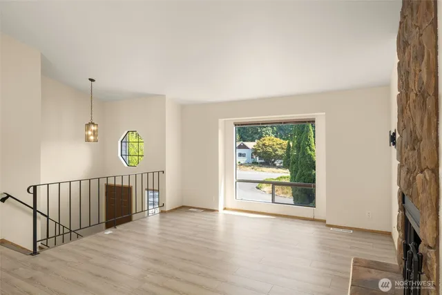 an empty room with windows toilet and entryway