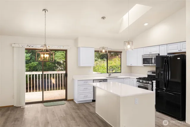 a kitchen with stainless steel appliances a refrigerator sink and stove