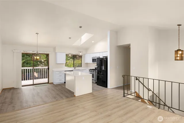 a view of a kitchen with a sink refrigerator and wooden floor
