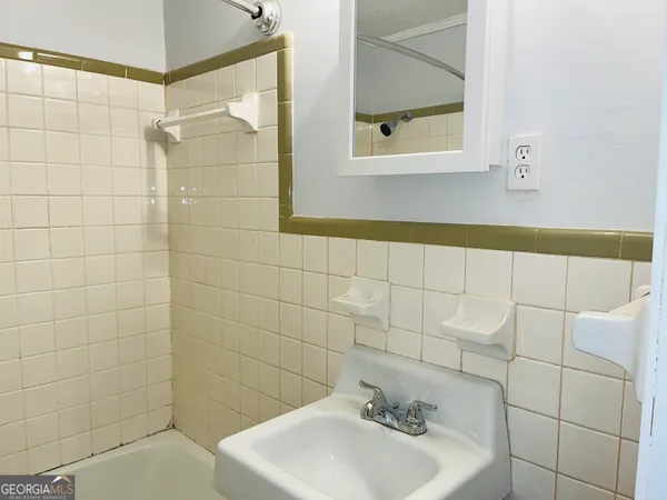 a bathroom with a sink a mirror and shower