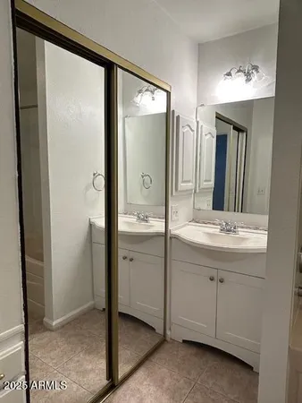 a bathroom with a double vanity sink mirror and shower