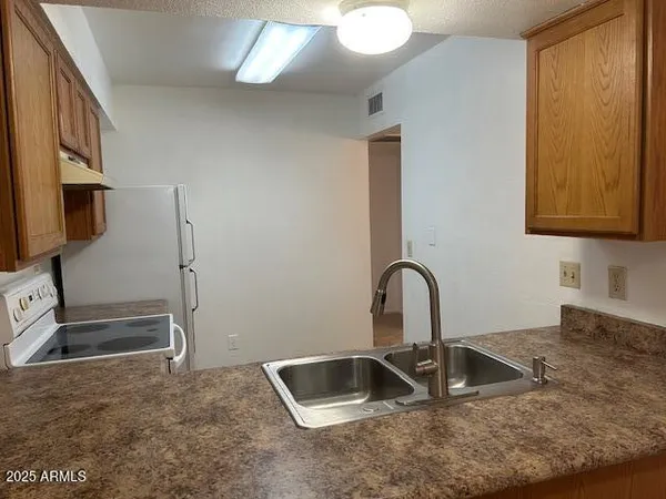 a kitchen with granite countertop a sink and a stove top oven