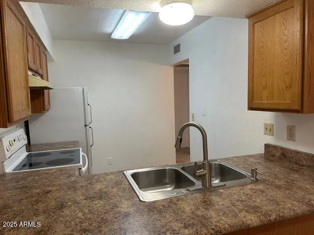 a kitchen with granite countertop a sink and a stove top oven