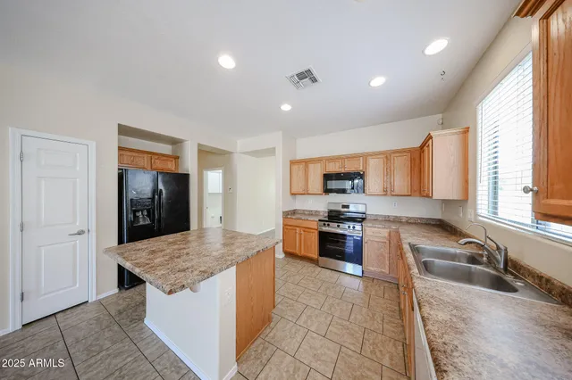 a kitchen with stainless steel appliances granite countertop a sink stove and refrigerator