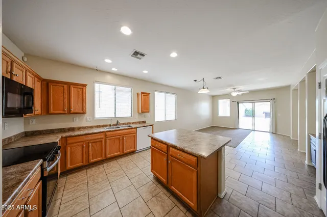 a kitchen with stainless steel appliances granite countertop a sink counter space cabinets and a large window