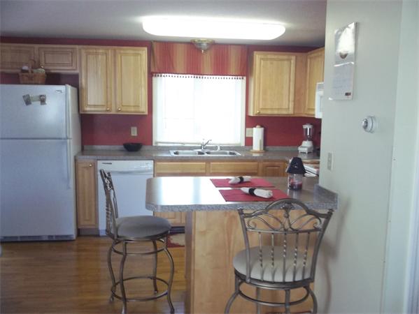 97 Belanger Street, Unit 97 Three Rivers, MA 01080 - Photo 3 of 13 a kitchen with stainless steel appliances granite countertop a sink cabinets and a refrigerator