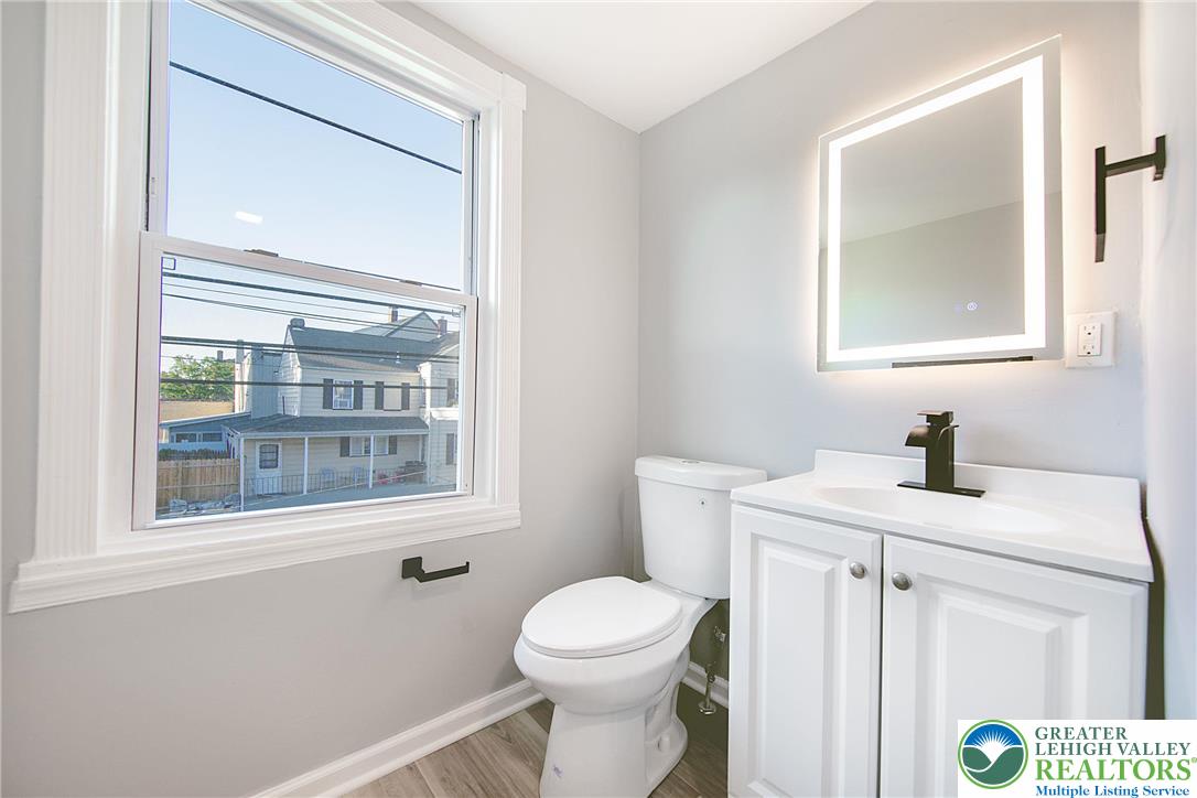 910 Butler Street Easton, PA 18042 - Photo 17 of 29 a bathroom with a toilet a sink a vanity and a mirror