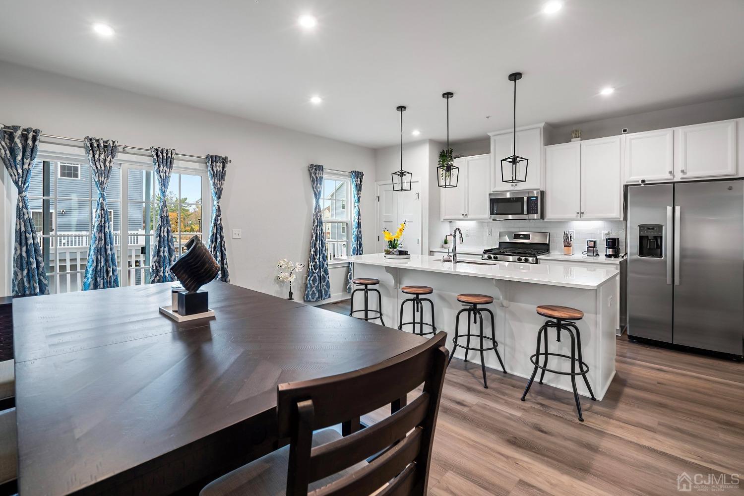 26 American Way Cliffwood, NJ 07721 - Photo 18 of 32 a kitchen with stainless steel appliances a dining table chairs and wooden floor