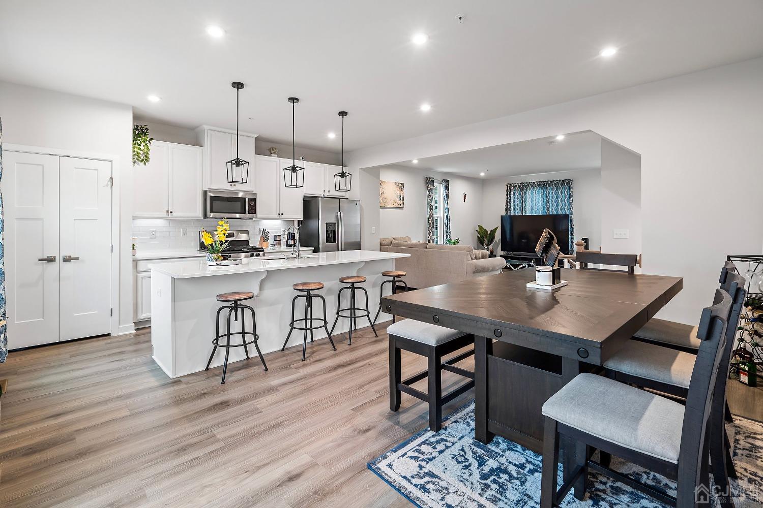 26 American Way Cliffwood, NJ 07721 - Photo 19 of 32 a kitchen with stainless steel appliances kitchen island granite countertop a dining table chairs and white cabinets