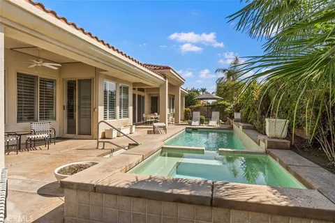 a view of a house with backyard and sitting area