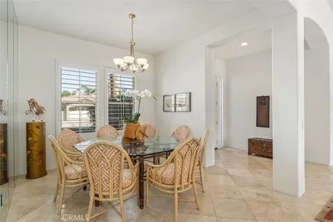 a dining room with furniture a chandelier and window