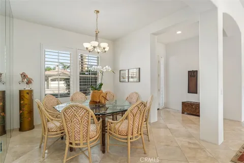 a dining room with furniture a chandelier and window
