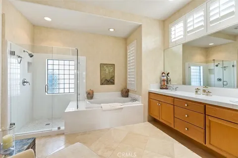 a spacious bathroom with a tub sink shower and mirror