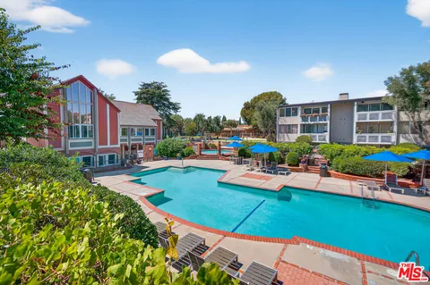 a front view of a house with swimming pool garden and patio