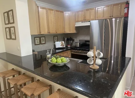 a kitchen with stainless steel appliances granite countertop a sink and a stove