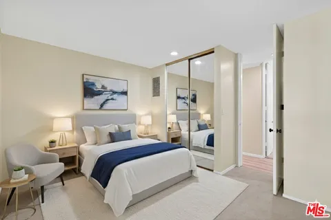 a bedroom with a bed and a large mirror