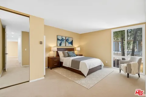 a bedroom with a bed and a large window