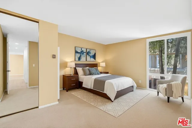 a bedroom with a bed and a large window