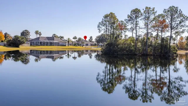 a view of swimming pool with a yard and palm trees
