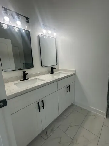 a bathroom with a double vanity sink and mirror