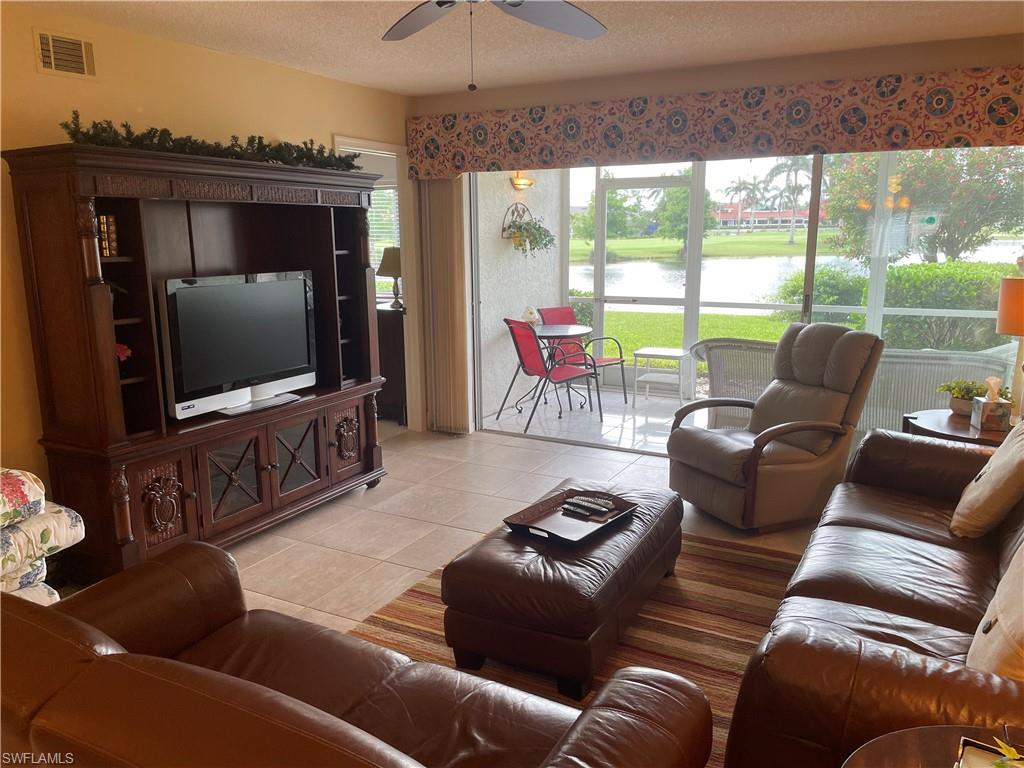 5970 Amherst Drive, Unit C103 Naples, FL 34112 - Photo 10 of 24 Living room with ceiling fan, light tile patterned flooring, and a textured ceiling