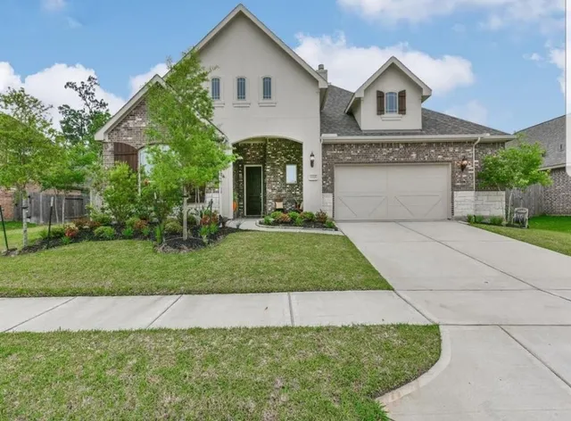 a front view of a house with a yard and garage