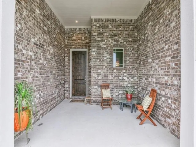 a building outdoor space with patio furniture and potted plants