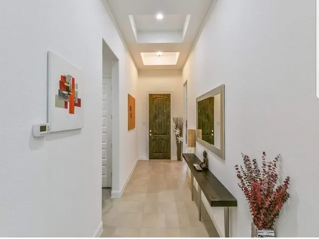 a hallway with beautiful frames and flower vase