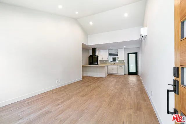 a view of a kitchen with furniture and wooden floor
