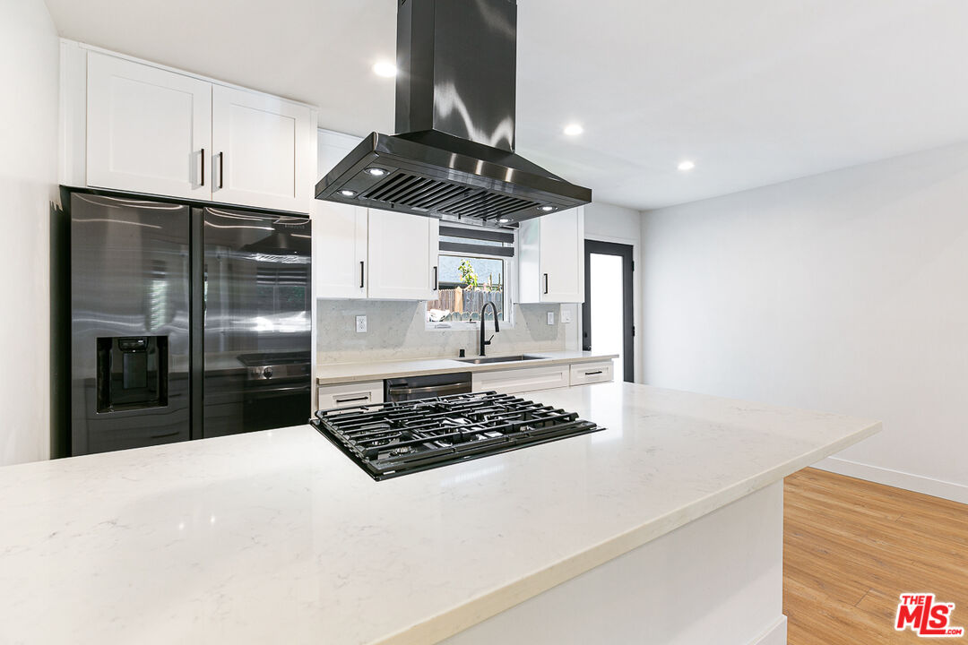 10420 Regent Street, Unit 10424 Los Angeles, CA 90034 - Photo 9 of 12 a kitchen with stainless steel appliances granite countertop a stove a refrigerator a sink a counter space and cabinets