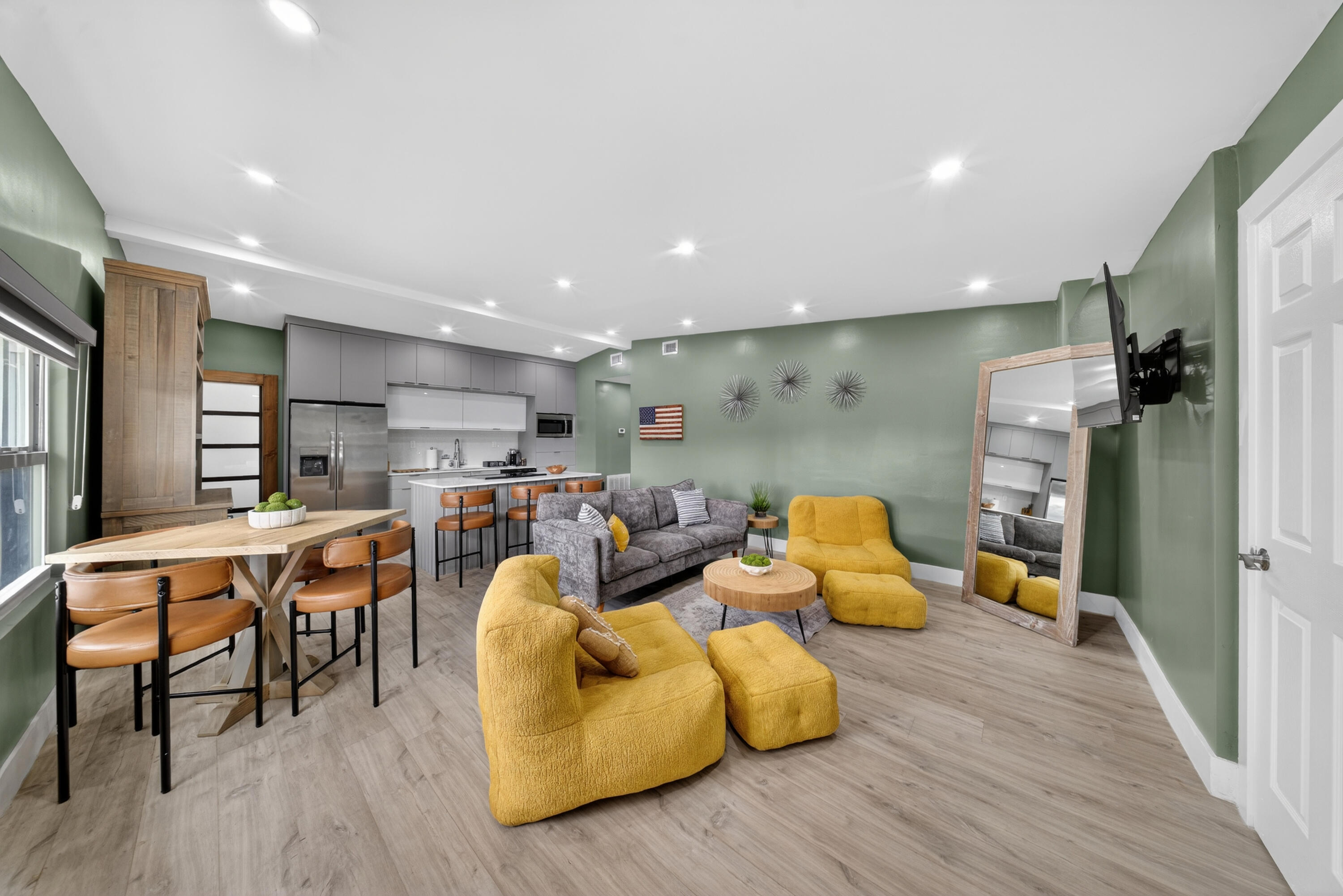 a living room with furniture kitchen view and a wooden floor