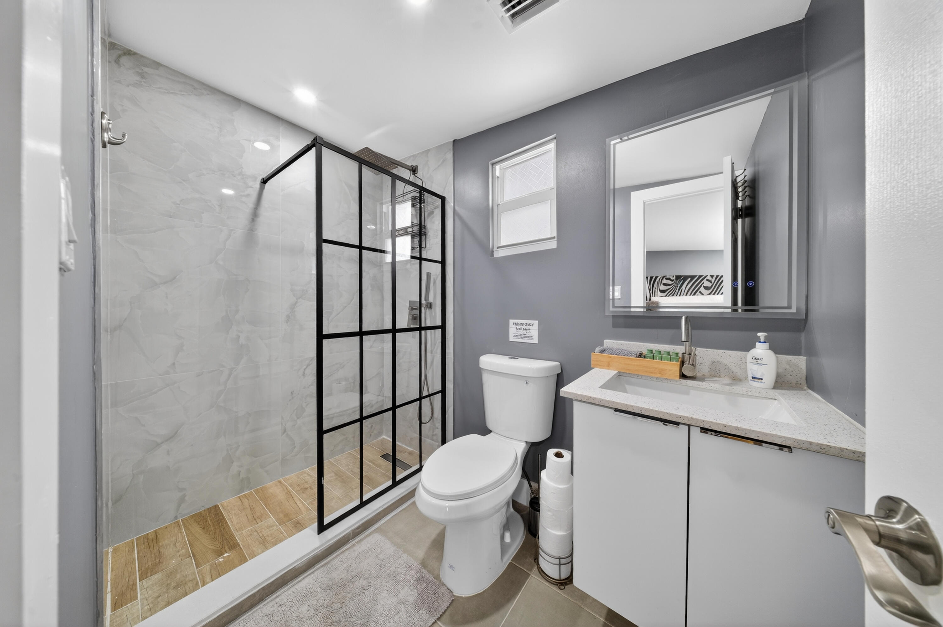 801 Southeast 15th Street Stuart, FL 34994 - Photo 16 of 25 a bathroom with a granite countertop sink toilet a mirror and shower