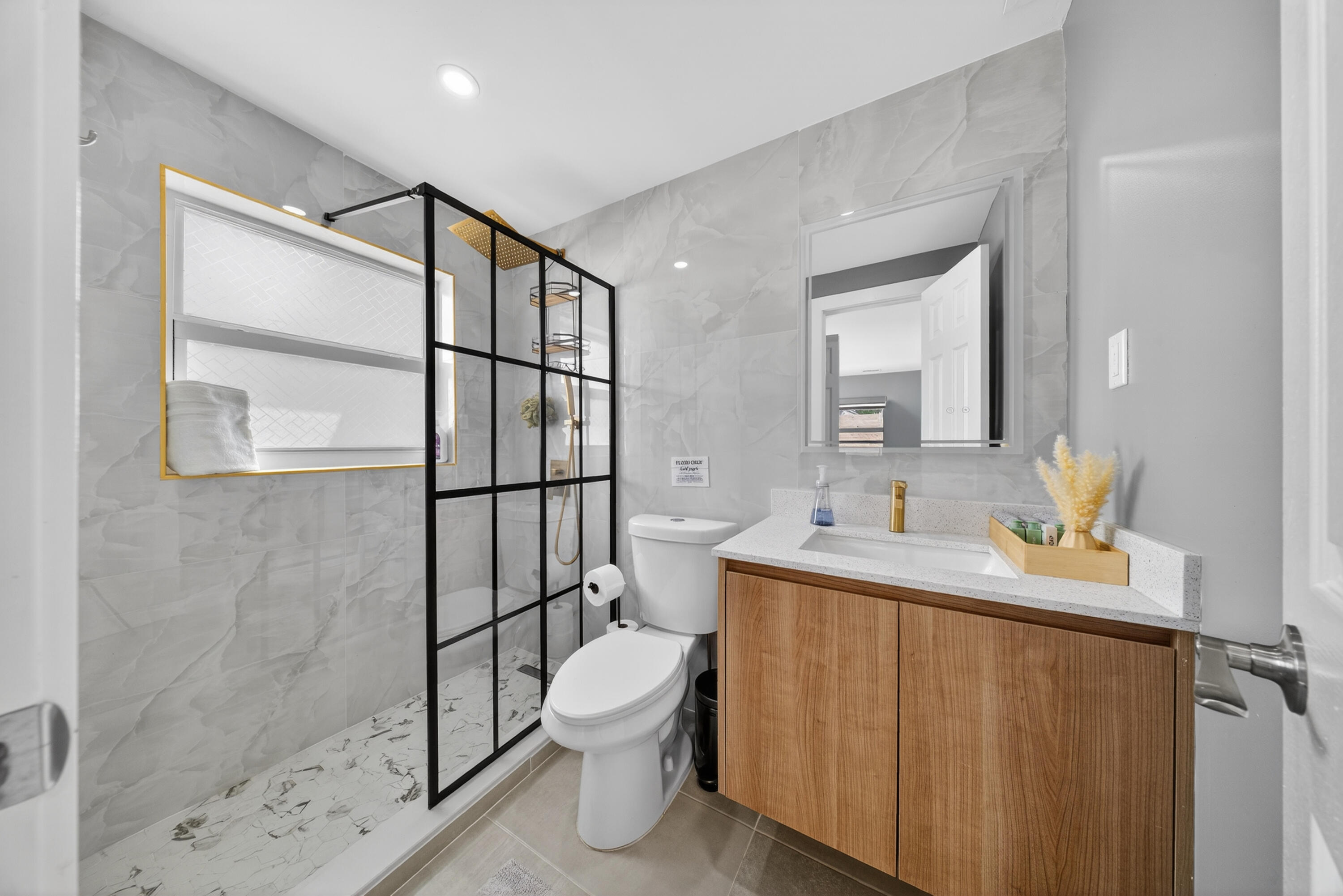 801 Southeast 15th Street Stuart, FL 34994 - Photo 10 of 25 a bathroom with a toilet sink vanity and mirror