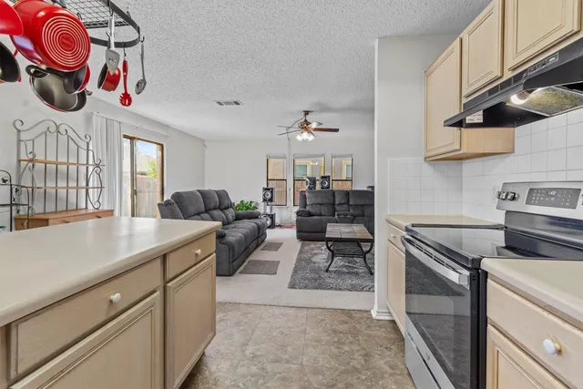 a kitchen with stainless steel appliances kitchen island granite countertop a table and chairs in it