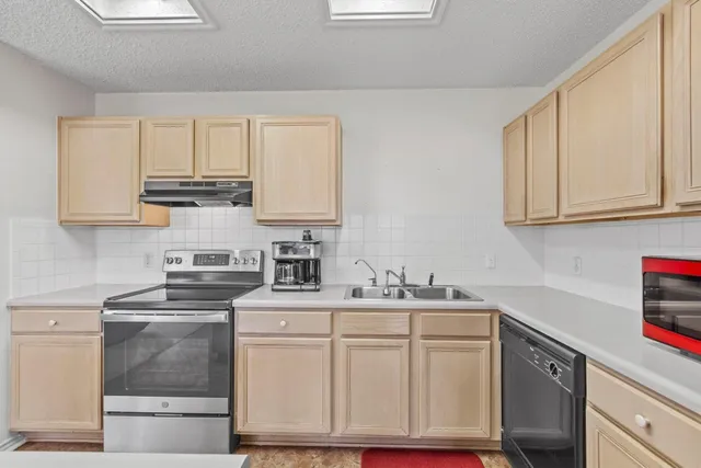 a kitchen with stainless steel appliances granite countertop a sink stove and cabinets