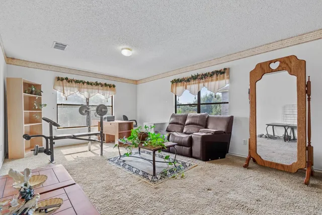 a living room with furniture a large window and gym equipment