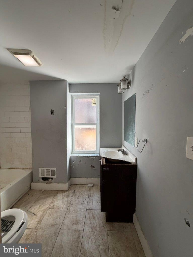 1409 East Lanvale Street Baltimore, MD 21213 - Photo 16 of 25 a view of a bathroom with a sink and mirror