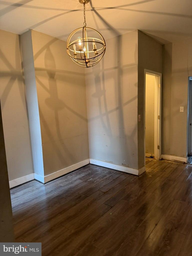 1409 East Lanvale Street Baltimore, MD 21213 - Photo 8 of 25 an empty room with wooden floor and chandelier