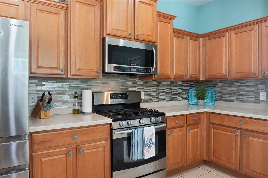 8746 Stone Harbour Loop Bradenton, FL 34212 - Photo 22 of 71 a kitchen with stainless steel appliances granite countertop a stove a microwave and cabinets
