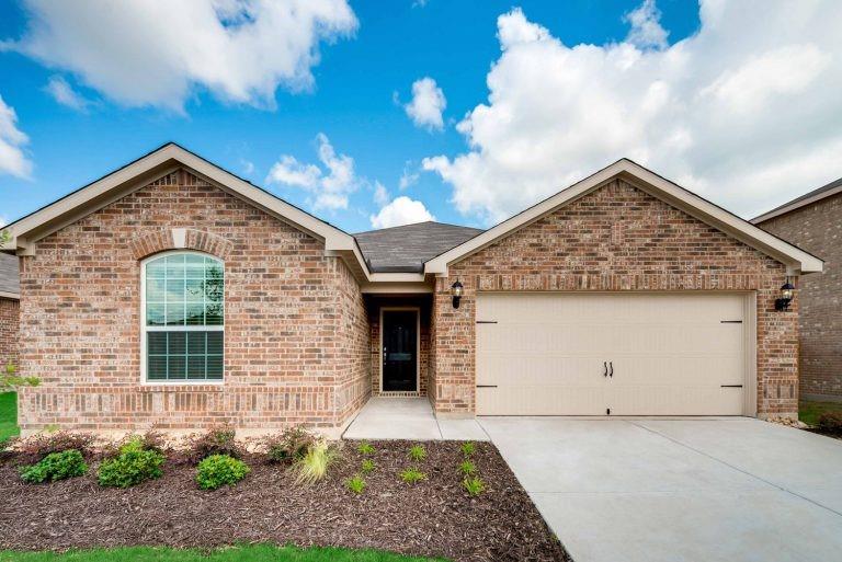 a front view of a house with plants