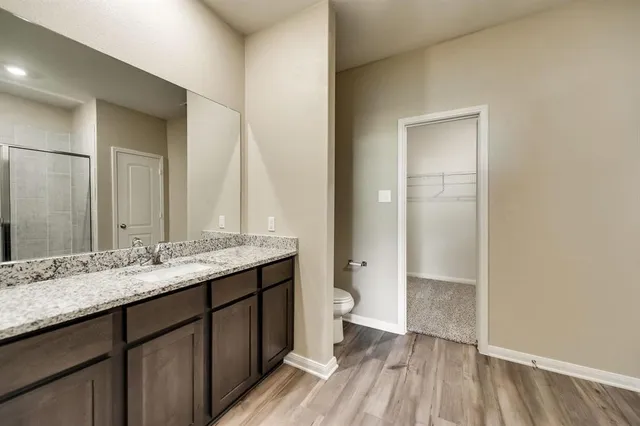 a bathroom with a granite countertop sink toilet and shower
