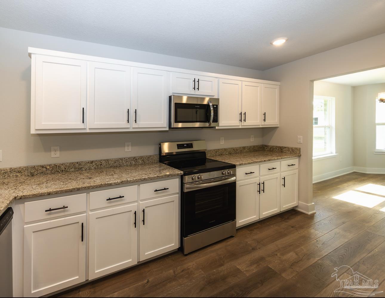 5303 Zenith Lane Milton, FL 32583 - Photo 11 of 16 a kitchen with granite countertop white cabinets and stainless steel appliances