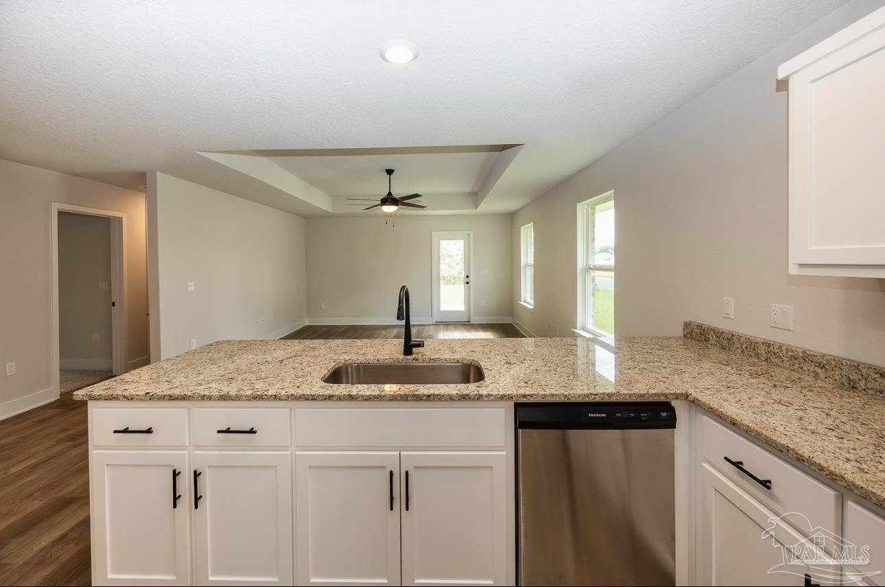 5303 Zenith Lane Milton, FL 32583 - Photo 12 of 16 a kitchen with stainless steel appliances granite countertop a sink and white cabinets with wooden floor