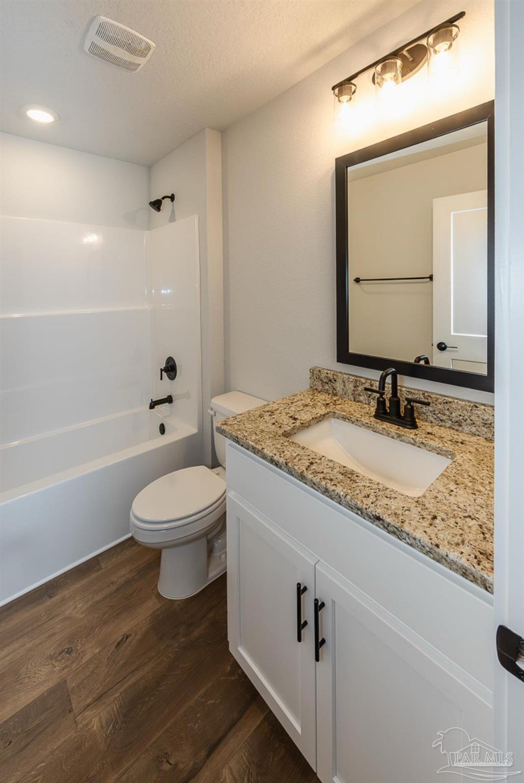 5303 Zenith Lane Milton, FL 32583 - Photo 14 of 16 a bathroom with a granite countertop sink toilet a mirror and bathtub