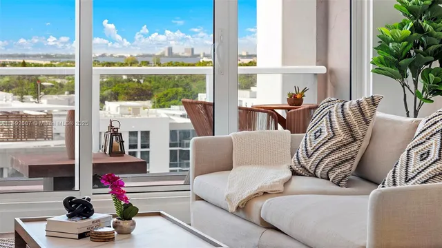 a living room with furniture fireplace and a large window