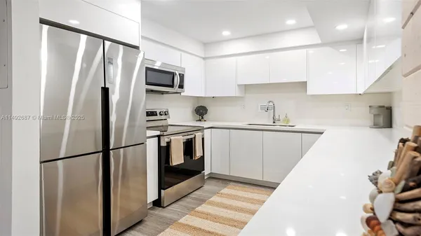 a kitchen with stainless steel appliances granite countertop a refrigerator a stove a sink and a microwave