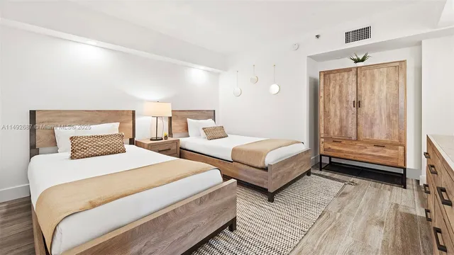 a bedroom with two beds and a dresser