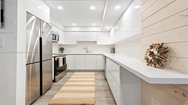 a kitchen with stainless steel appliances a refrigerator sink and cabinets
