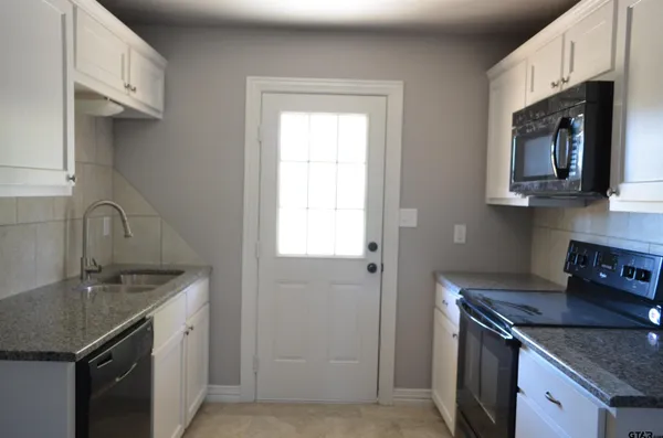 a kitchen with stainless steel appliances granite countertop a sink stove and cabinets