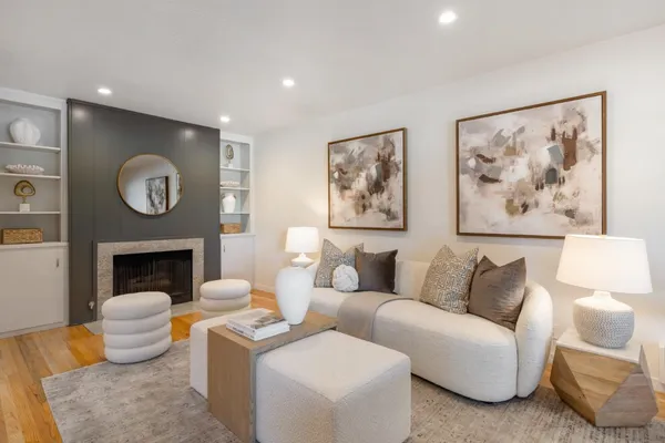 a living room with furniture a fireplace and wall paintings